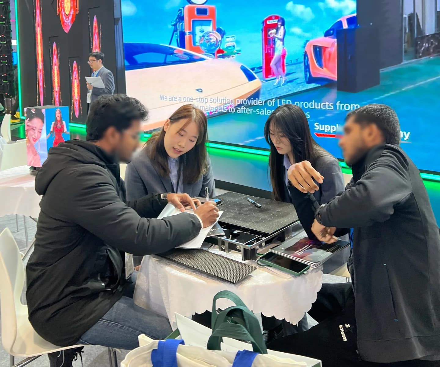 Stellux team discussing an LED cabinet solution at an industry exhibition