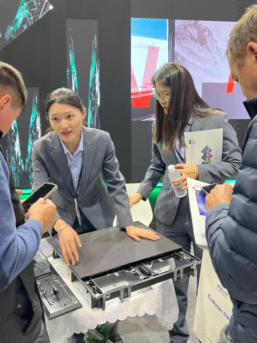 Stellux team demonstrating an LED display cabinet to visitors